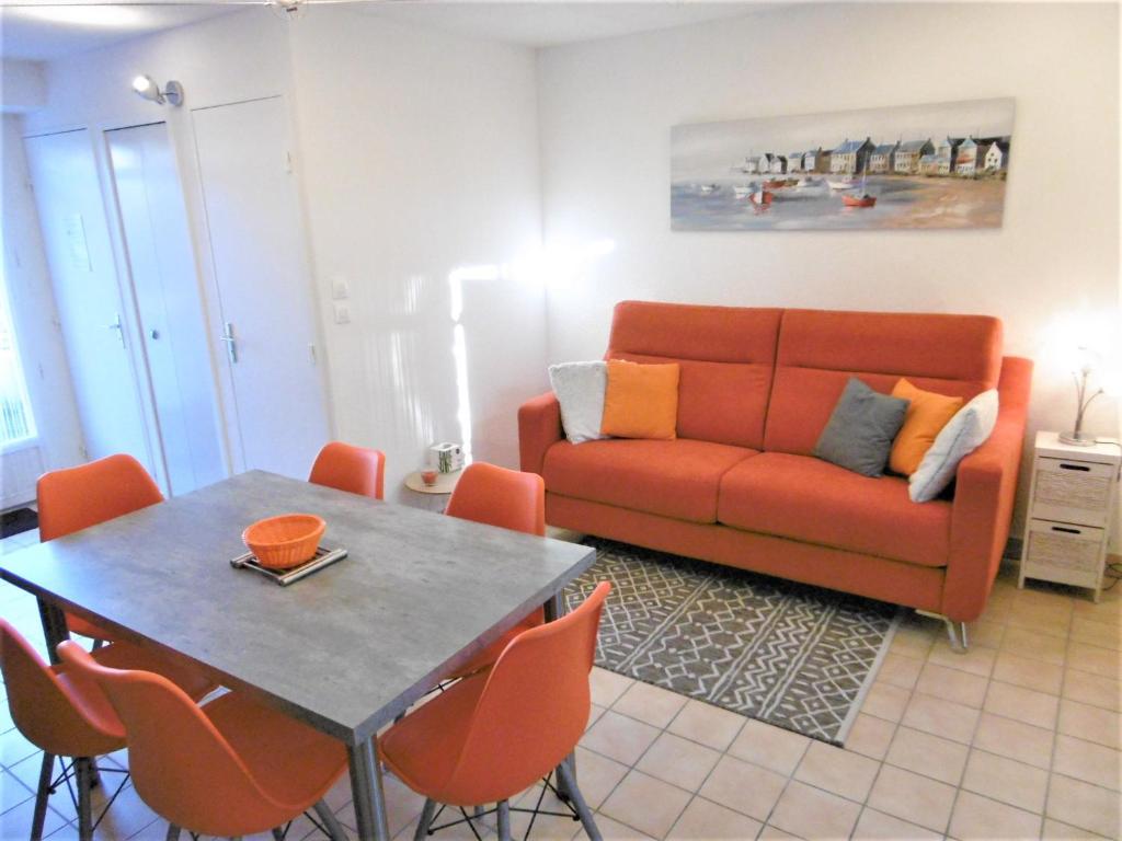 a living room with a couch and a table at Maisonnette JIKEL à 50 m de la plage in Sarzeau