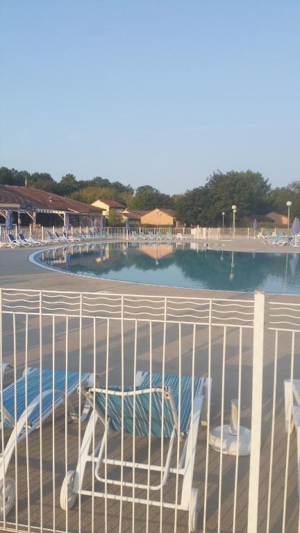 Blick auf den Pool von hinter einem Zaun in der Unterkunft CARPE DIEM - La Villa des Vacances in Soustons