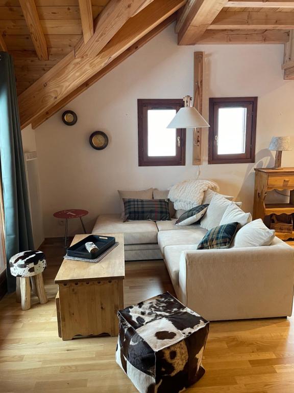 a living room with a couch and a table at Les Loups Blancs, duplex rénové en 2022, pied des pistes in Montgenèvre