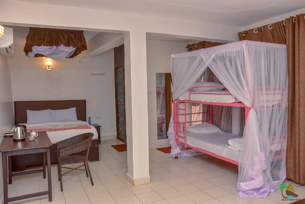 um quarto com um beliche, uma mesa e uma cama em Beach View Hotel - Kisumu em Kisumu