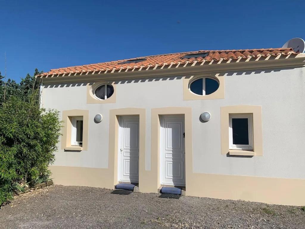 une maison blanche avec deux portes dans l'établissement LA MAISONNETTE DU PONTREAU, à La Pironnière