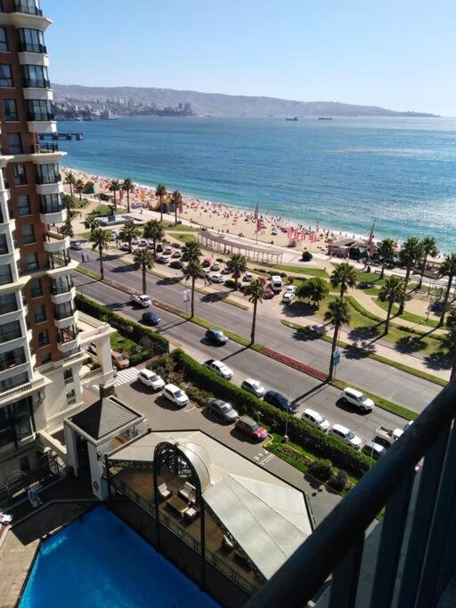 una vista sulla spiaggia da un balcone di un edificio di Hermoso departamento frente al Mar a Viña del Mar