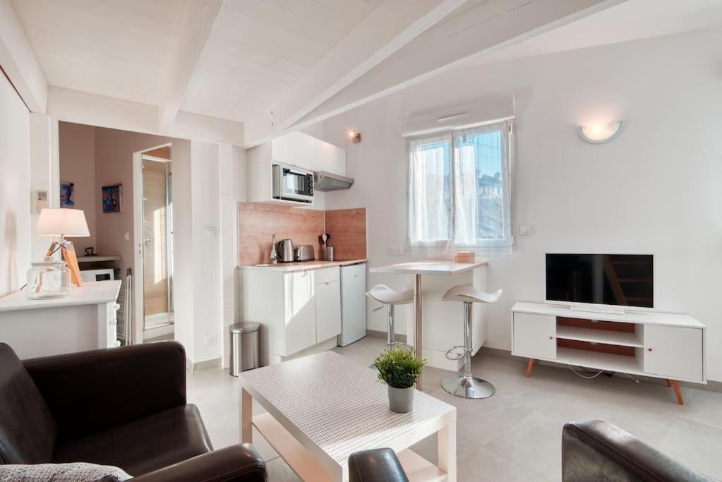 uma sala de estar com um sofá e uma mesa em Le 101 - Studio avec mezzanine à 20 min à pied Gare St-Charles em Marselha