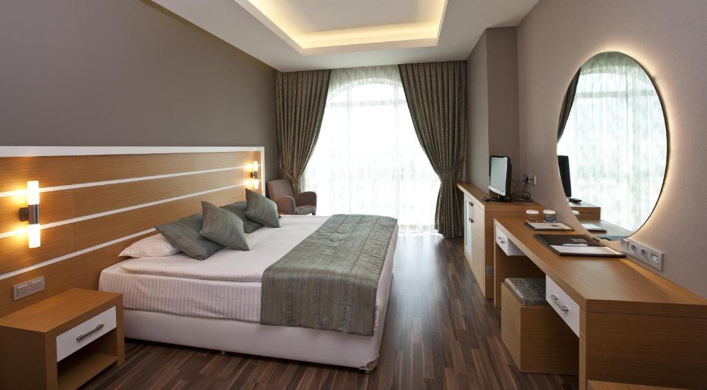 Habitación de hotel con cama y escritorio en Fourway Hotel&Spa, en Dortyol