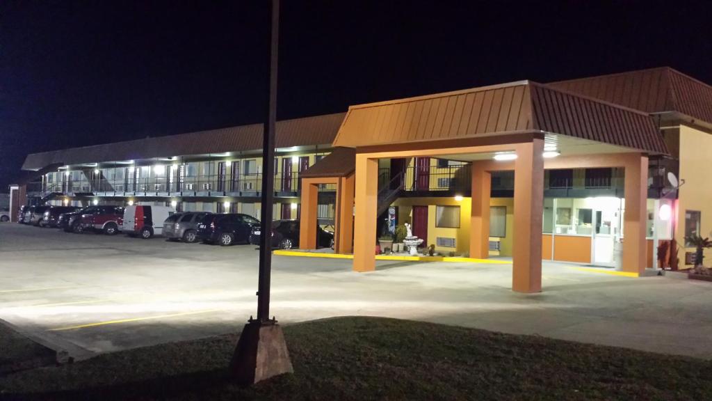 a large building with a parking lot at night at Western Motel - Jesup in Jesup