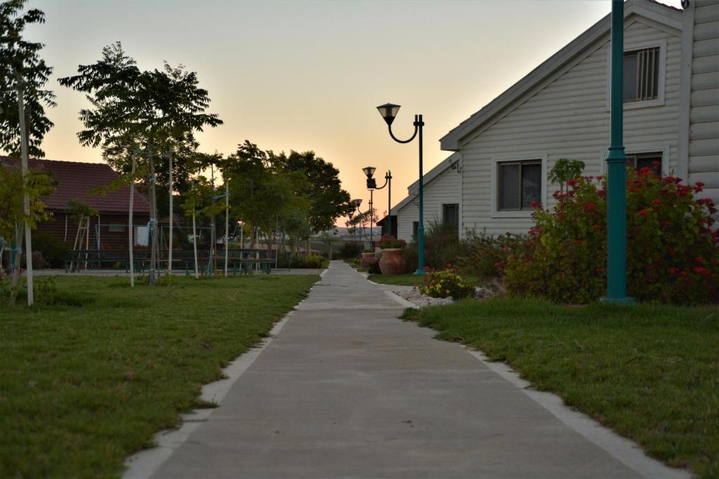 a sidewalk next to a building and a house at Gan Hakramim Country Lodging in Kramim