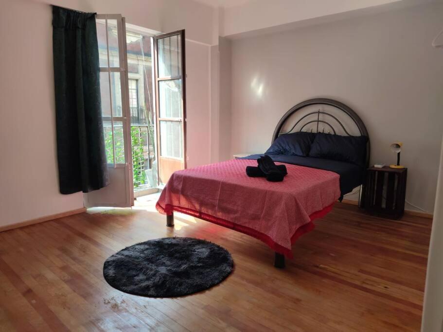 sypialnia z łóżkiem z czerwonym kocem w obiekcie Departamento 101 La Santisima w mieście Meksyk