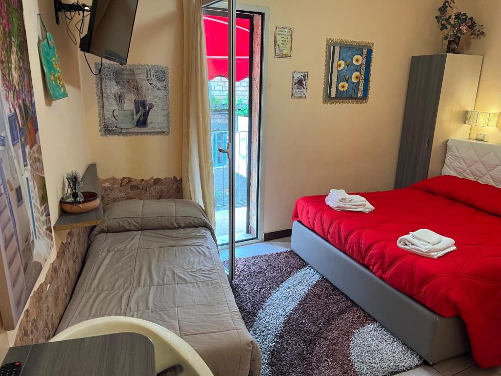 una camera con letto rosso e finestra di Golden Dreams Reggio Calabria a Reggio di Calabria