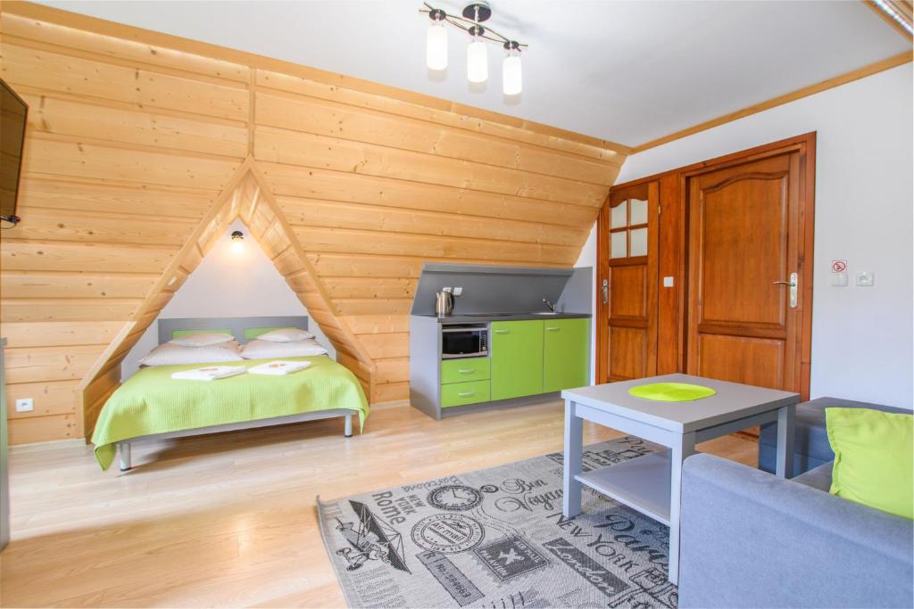 - une chambre avec un lit dans une pièce dotée de murs en bois dans l'établissement Willa U Futra, à Zakopane