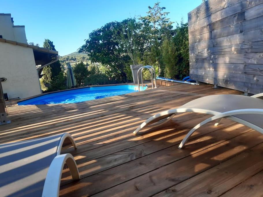 une terrasse en bois à côté d'une piscine dans l'établissement Villa Les Roches Blanches Le Ptit du Sud, à Martigues