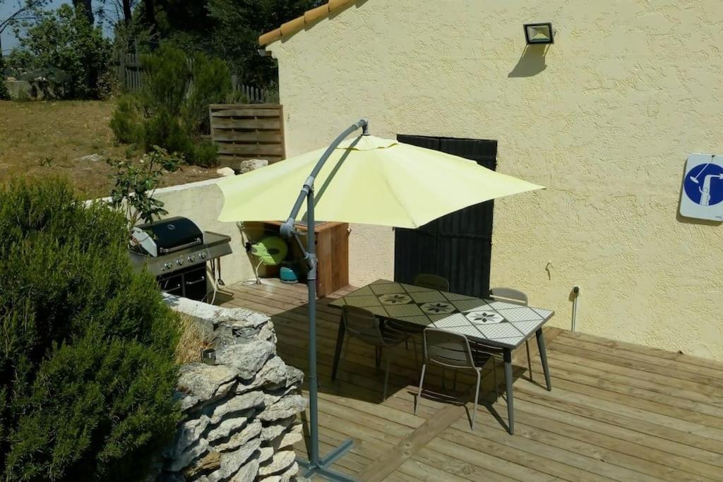 a yellow umbrella sitting next to a table and a grill at Villa Les Roches Blanches Le Ptit du Sud in Martigues