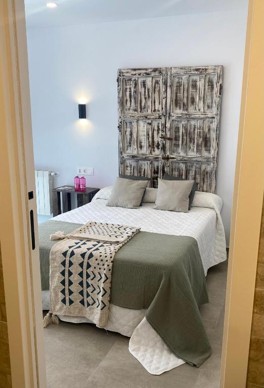 a bedroom with a large bed with a large headboard at Alojamiento El Miajon de los Castúos in Valdesalor
