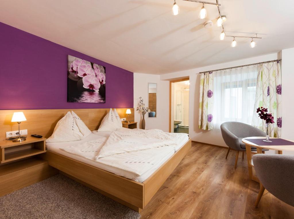 1 dormitorio con cama y pared púrpura en Roslerhof, en Inzing