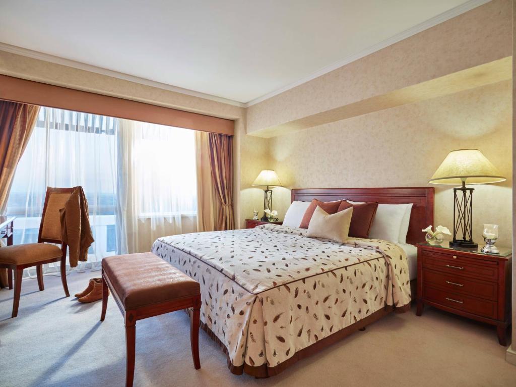 a hotel room with a bed and a large window at Taj Pamodzi Lusaka in Lusaka