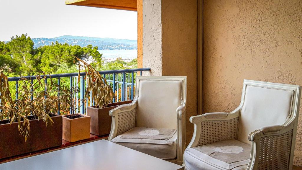 two chairs and a table on a balcony at Neptune in Cavalaire-sur-Mer