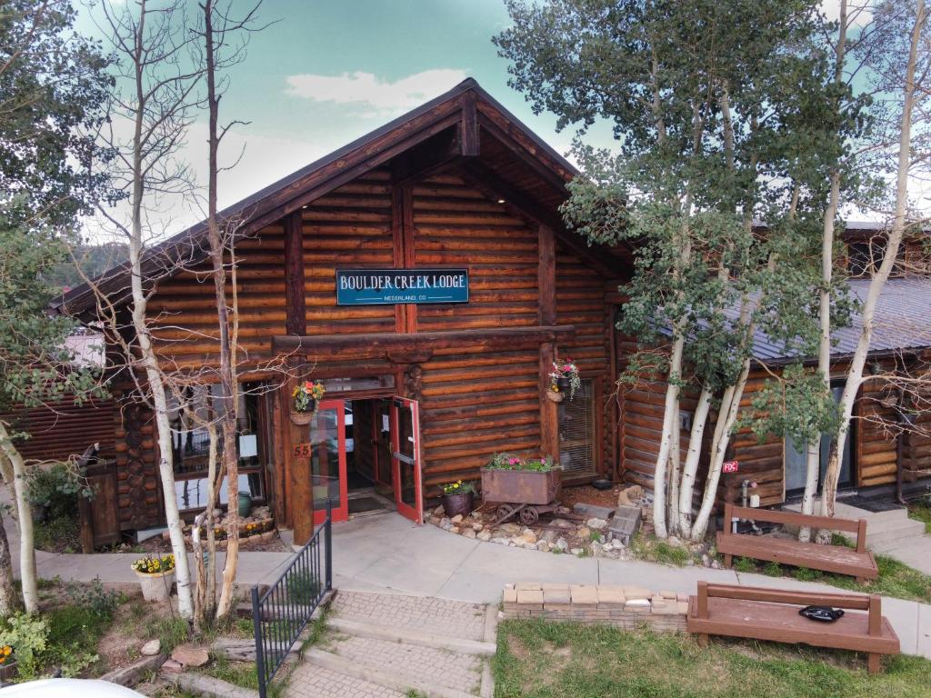 una cabaña de madera con un cartel en la parte delantera en The Boulder Creek Lodge en Nederland