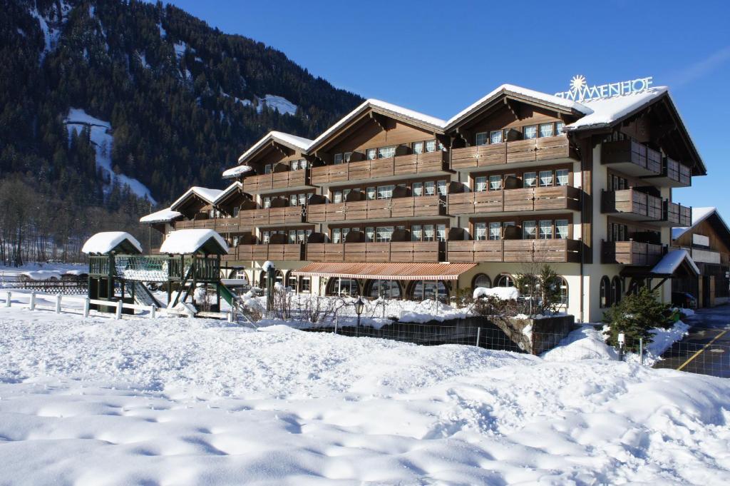 ein großes Gebäude mit Schnee davor in der Unterkunft Hotel Simmenhof in Lenk im Simmental