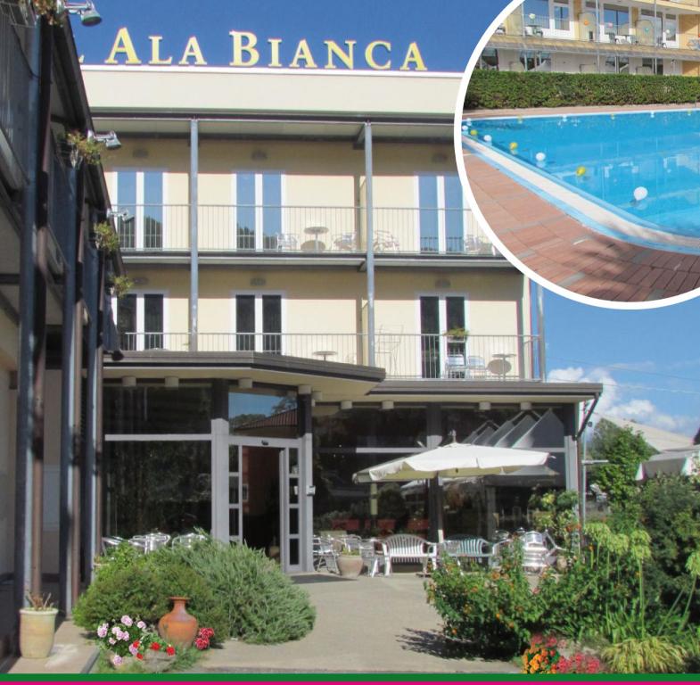 アメーリアにあるHotel Ala Biancaの大きな建物で、目の前にスイミングプールがあります。