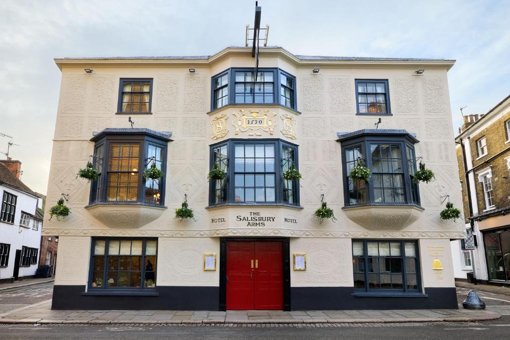 Salisbury Arms Hotel في هيرتفورد: مبنى ابيض كبير بباب احمر