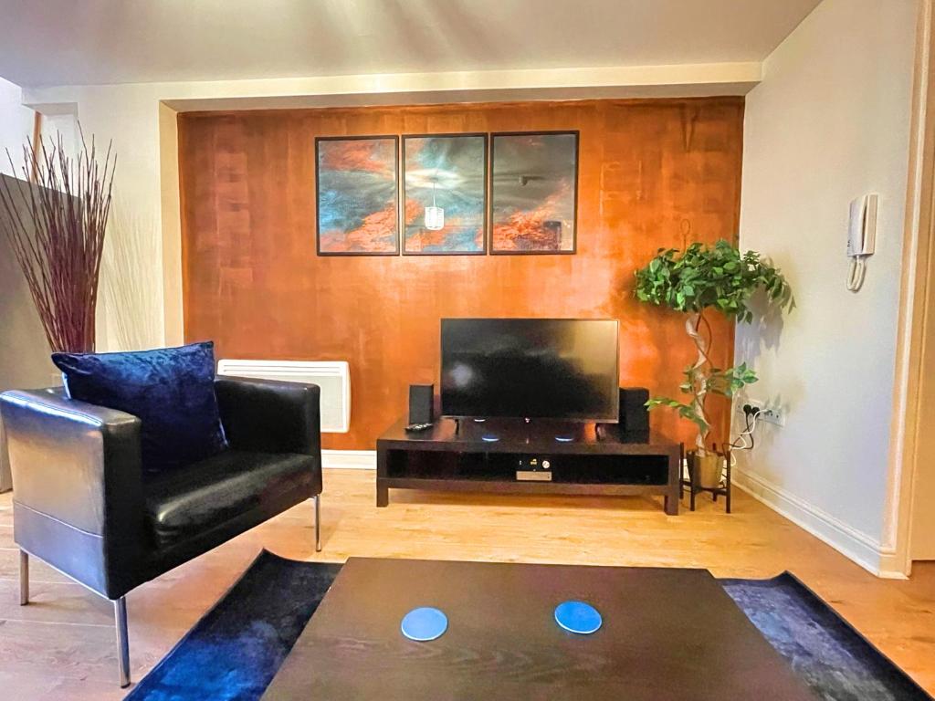 a living room with a black chair and a television at Centrally Located Loft Apartment in Sheffield