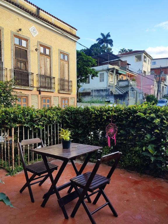 uma mesa de piquenique e duas cadeiras em frente a um edifício em Casarão artístico em Santa Teresa no Rio de Janeiro