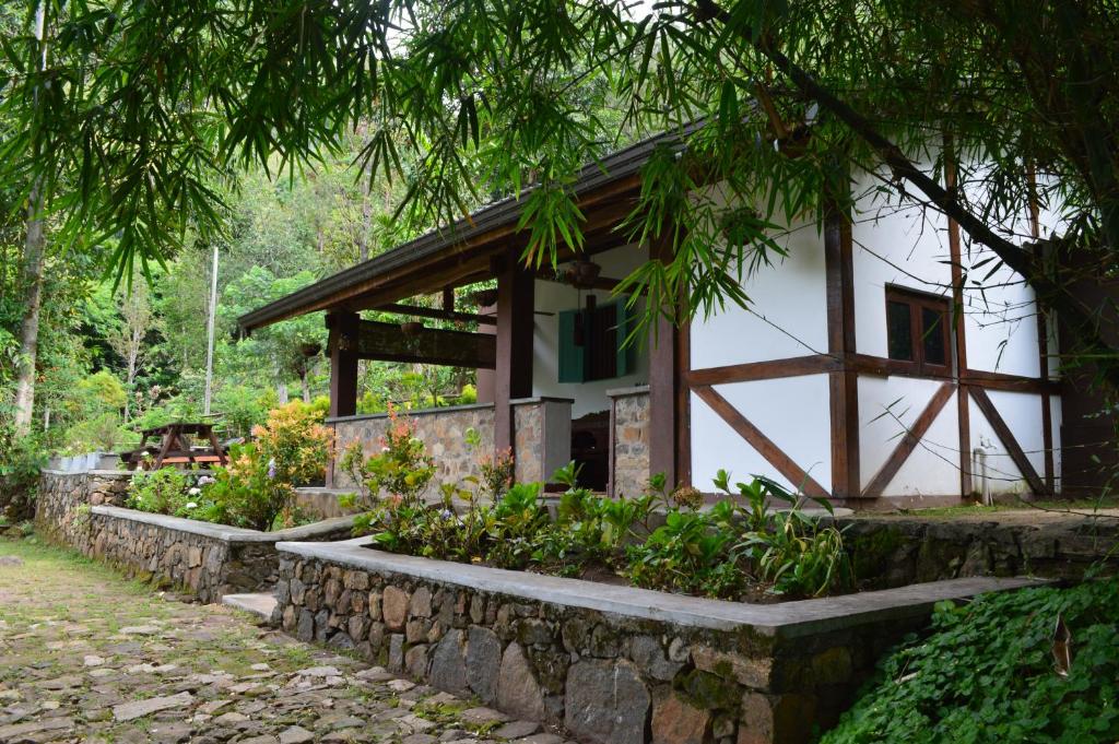 um chalé na floresta com uma parede de pedra em The Cottage at Galapitiyaya Estate for 6 em Haputale