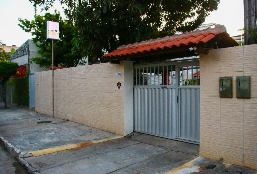 ポルト・デ・ガリーニャスにあるSuites Cariocaの門と柵のある建物