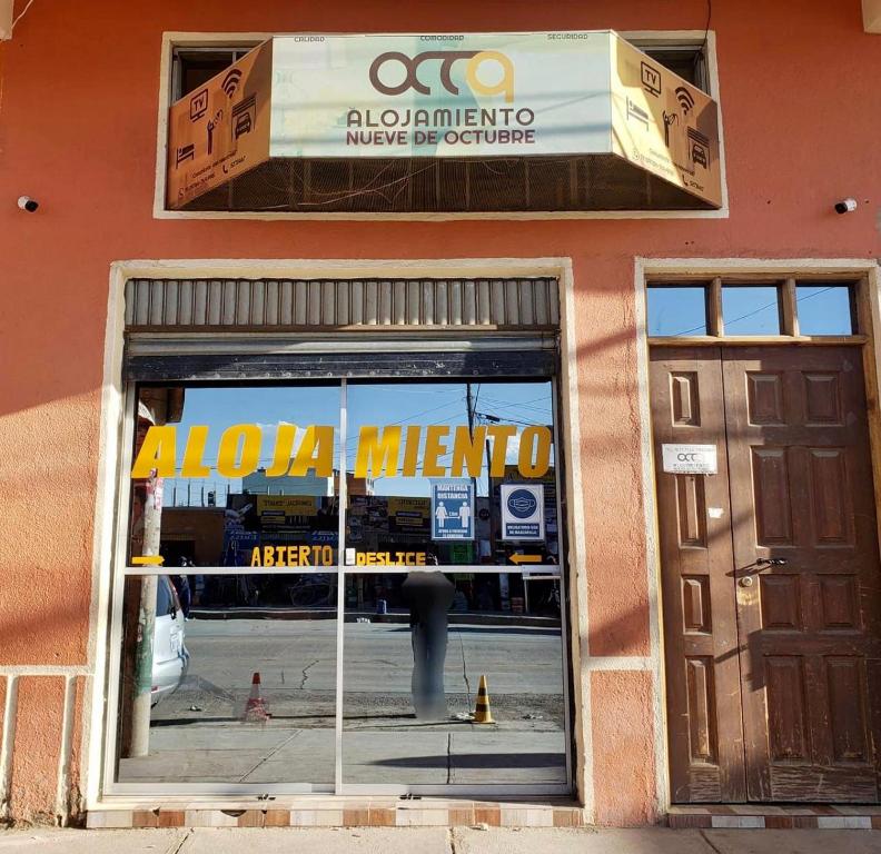 Una ventana de una tienda con un cartel. en 9 de octubre, en Oruro