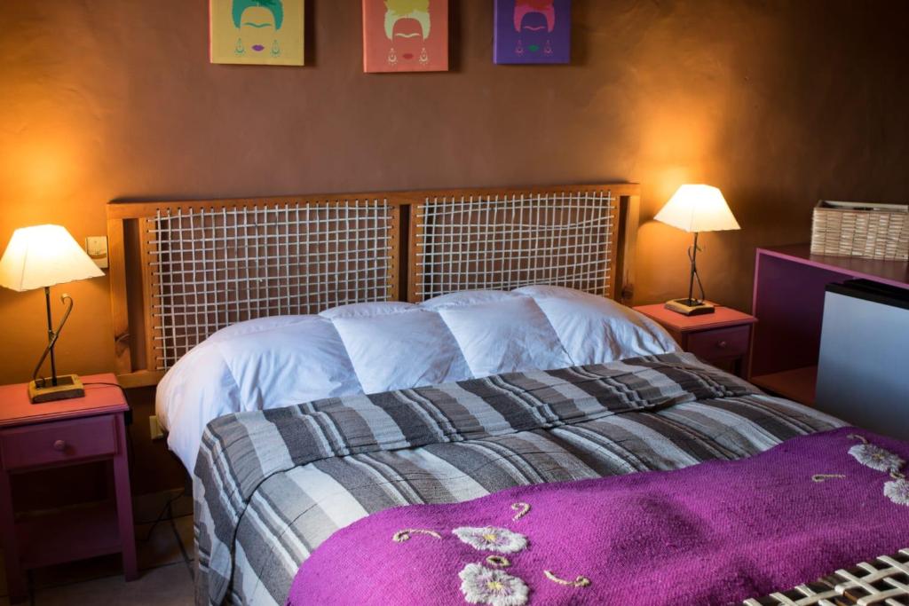 a bedroom with a large bed with two night stands at La Posada de Tafi in Tafí del Valle