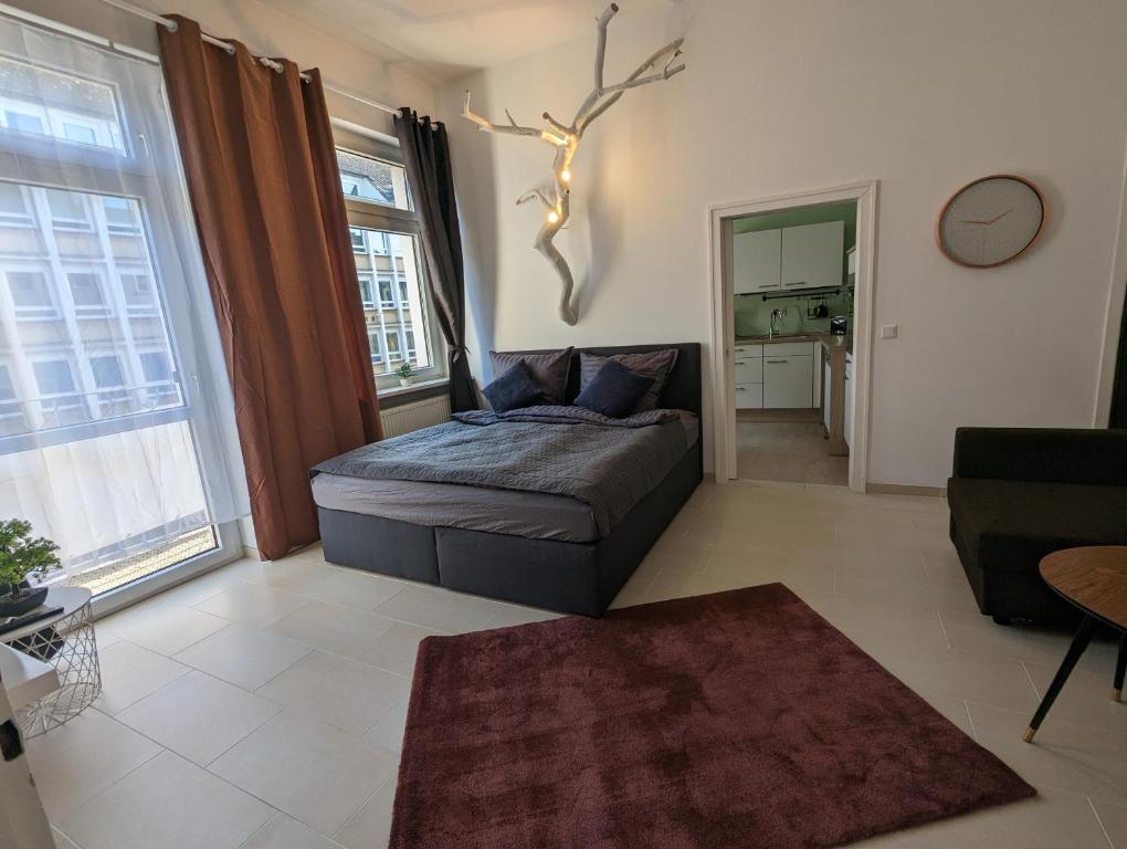 ein Schlafzimmer mit einem Bett und ein Wohnzimmer in der Unterkunft Schönes Apartment Mitten in der Stadt III in Koblenz