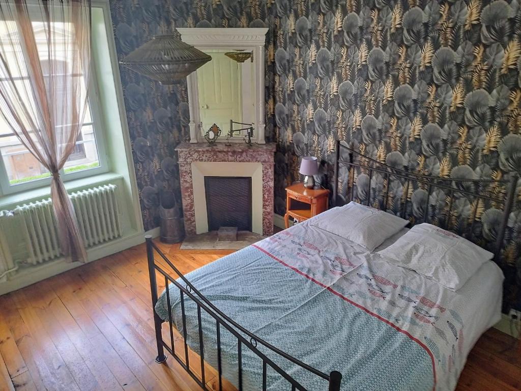 a bedroom with a bed and a fireplace at Chaleureuse maison de ville à côté de la mairie ronde in Ambert