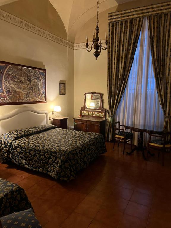 フィレンツェにあるホテル ヴィラ リアナのベッド2台と窓が備わるホテルルームです。