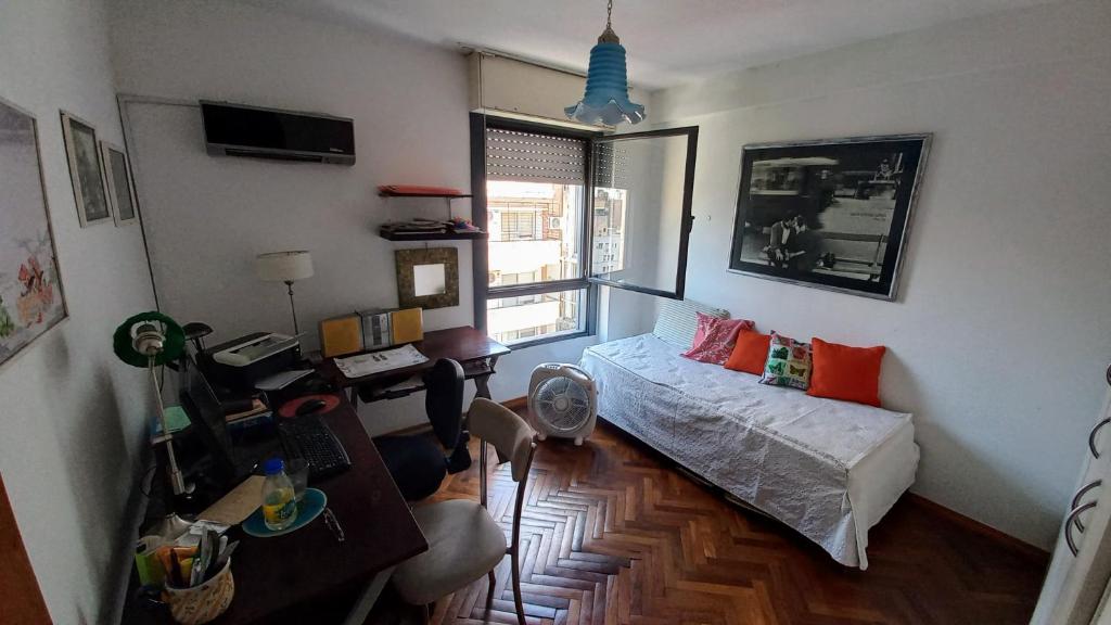 sala de estar con cama y escritorio en Moni Te Aloja en Rosario
