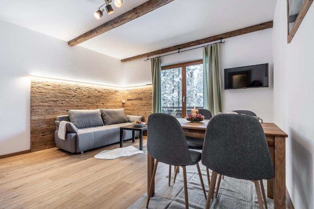 a living room with a couch and a table and chairs at Haus Hohenwiesen in Lenggries