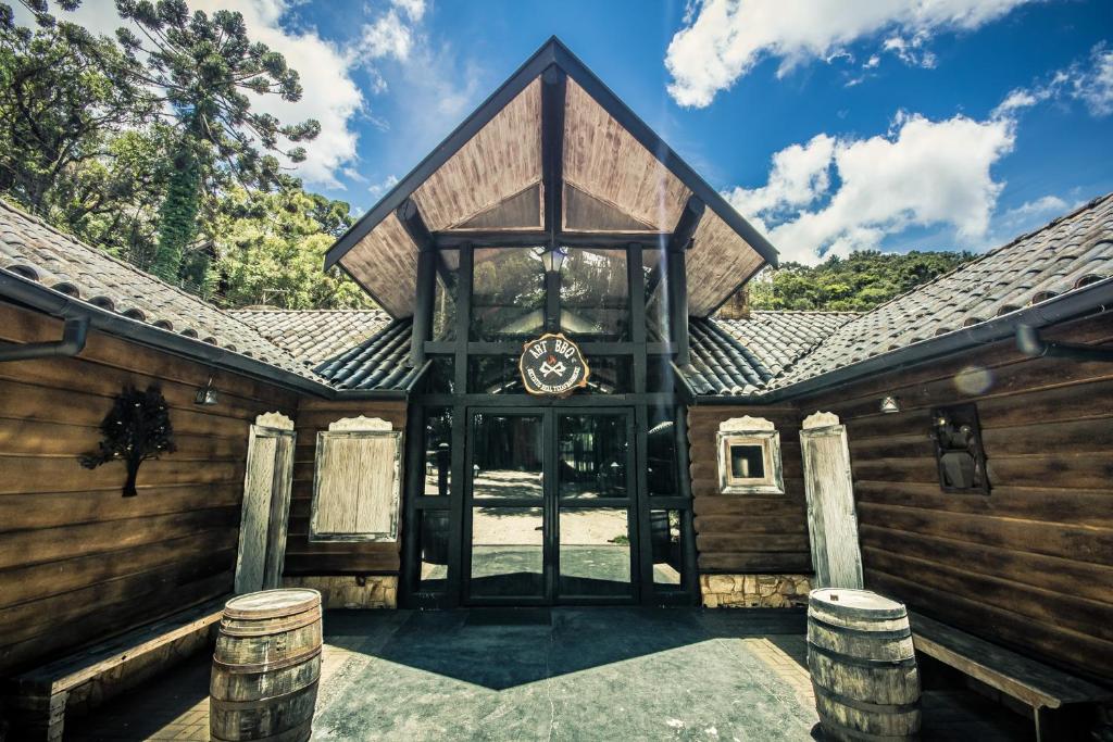 ein Holzhaus mit einer Glastür und einigen Bäumen in der Unterkunft Art Lodge in Campos do Jordão