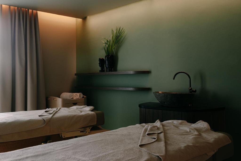 a hotel room with two beds and a sink at Hôtel & Spa Belle Plage in Cannes