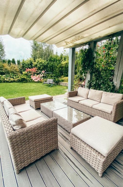 patio z wiklinowymi meblami na drewnianym tarasie w obiekcie Villa Mila w mieście Mikołajki