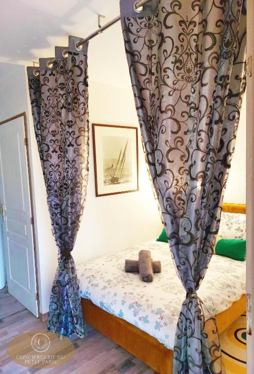a bedroom with a bed with curtains on it at Magnifique appartement 2 pièces in Deauville