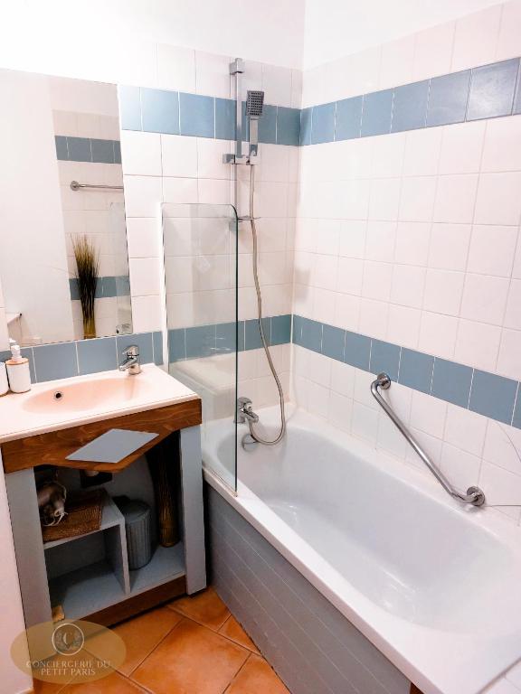a bathroom with a bath tub and a sink at Magnifique appartement 2 pièces in Deauville