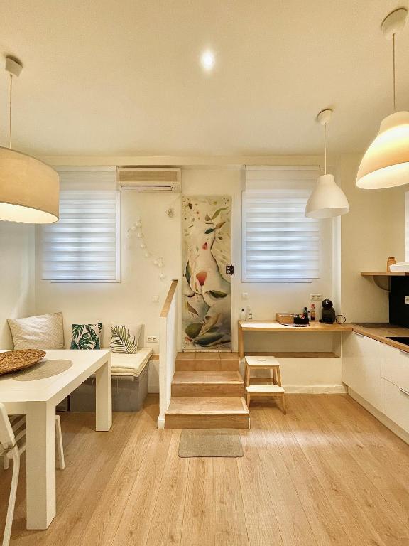 a kitchen and living room with a staircase and a table at El Apartamento de Trini en la Alameda in Seville