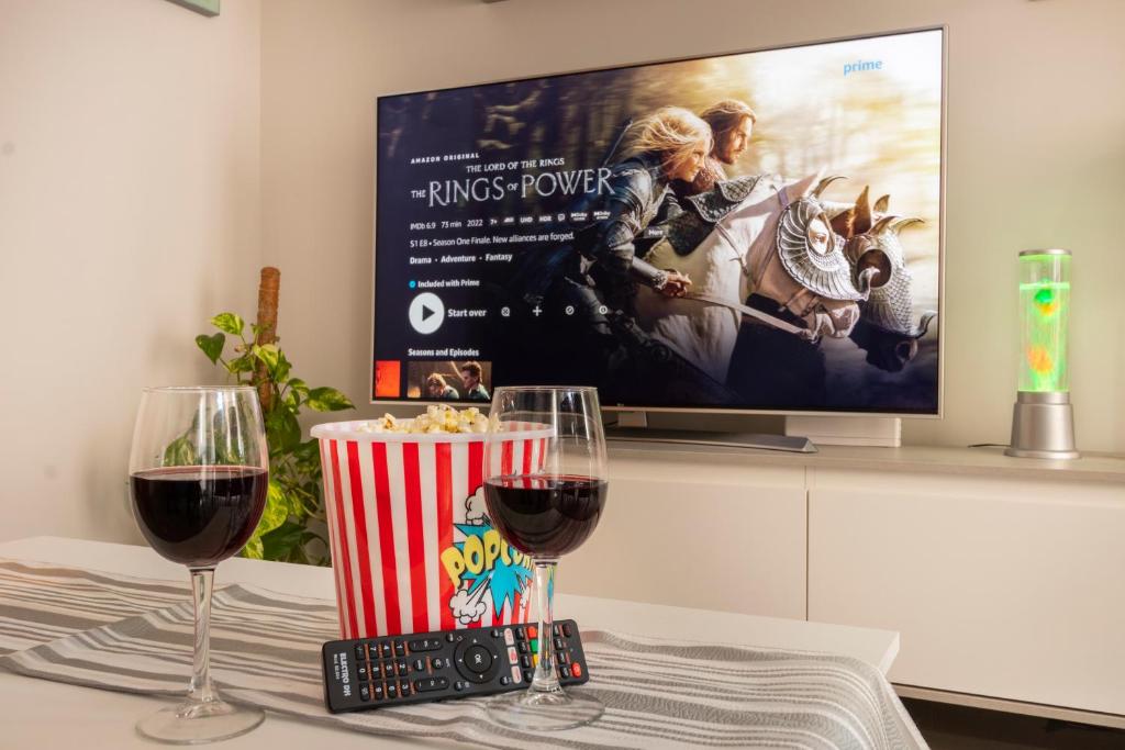 - une table avec 2 verres de vin et une télévision dans l'établissement Icon Center, à Almería