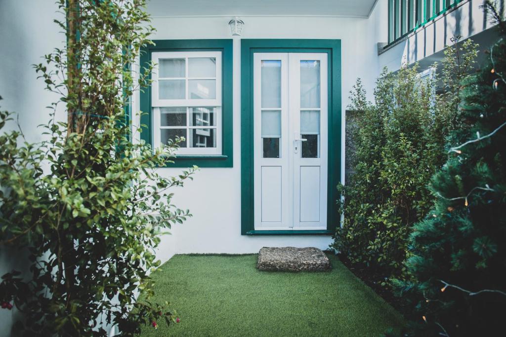 a white house with a door and a window at Casa de Couros in Guimarães