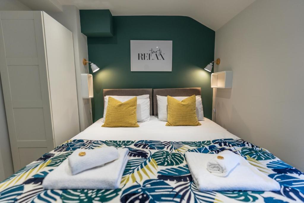 a bedroom with a bed with blue and yellow pillows at The Hive Apartment in Marple