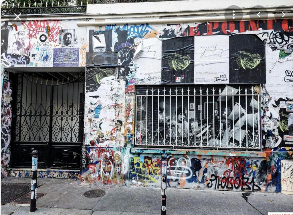 um edifício coberto de graffiti com um portão em Studio de Charme de Verneuil em Paris