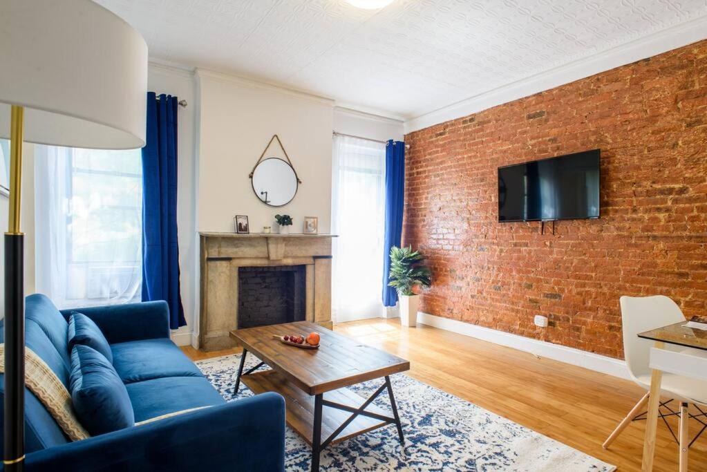a living room with a blue couch and a brick wall at 454-4R New 2BR prime midtown Best value Sleeps 5 in New York
