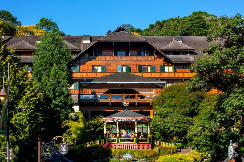 um grande edifício com um gazebo em frente em Hotel Casa da Montanha em Gramado