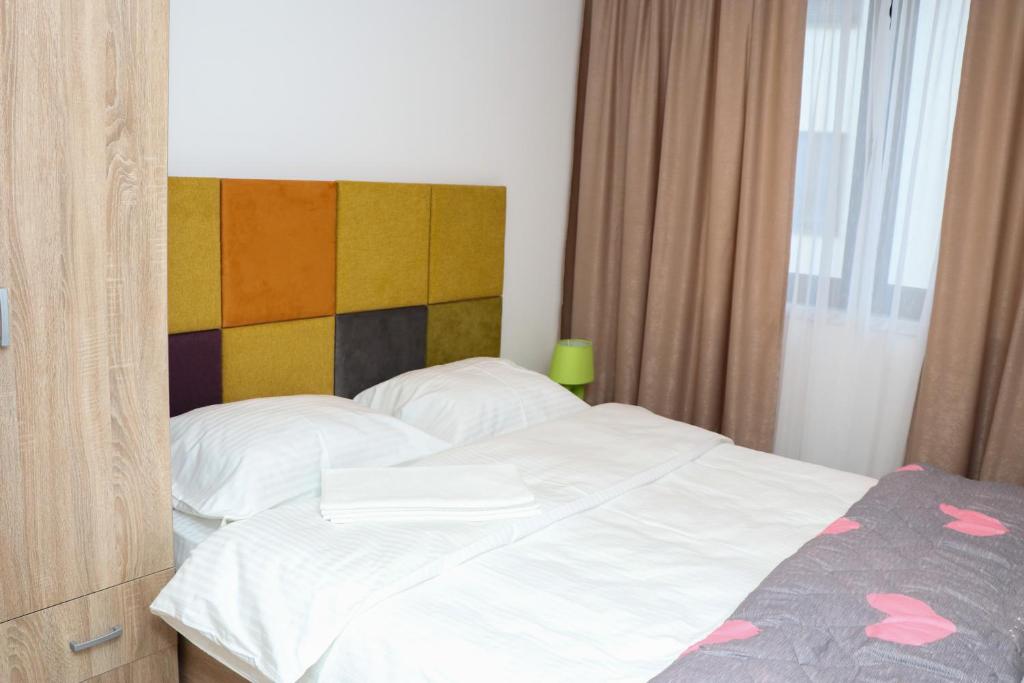 Dormitorio con cama blanca y cabecero colorido en Apartman Maksim Ravna Planina, en Pale