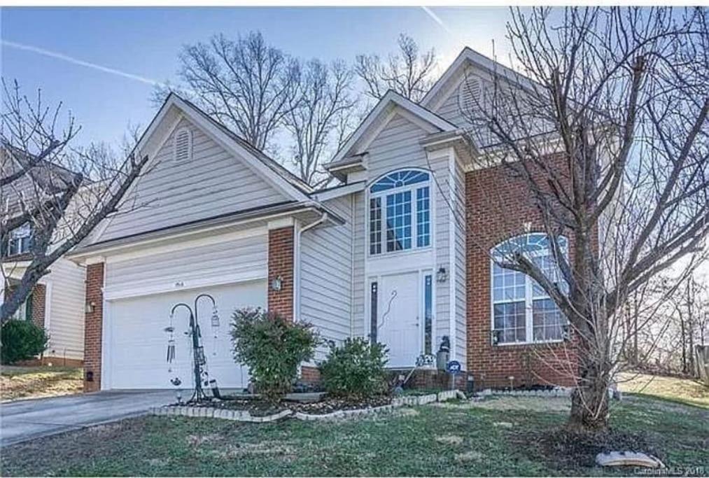 a house with a white garage and a brick house at Cozy 4B 2 5B University Home King Beds Jacuzzi in Charlotte