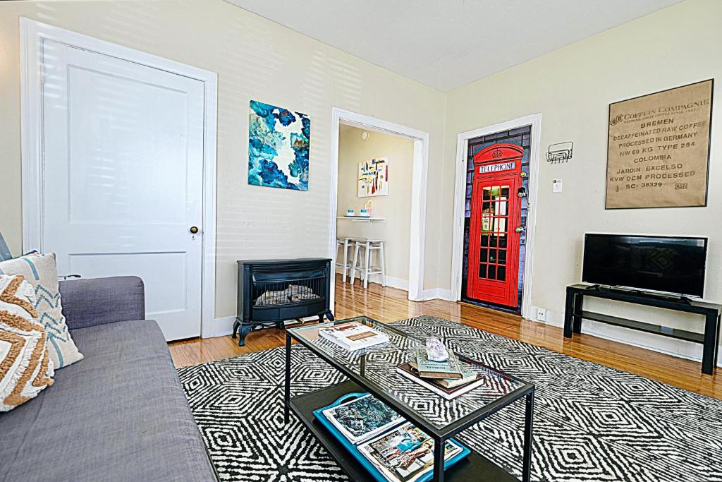 uma sala de estar com um sofá e uma porta vermelha em 1920s Urban Charm Aboretum Tickets Available em Dallas