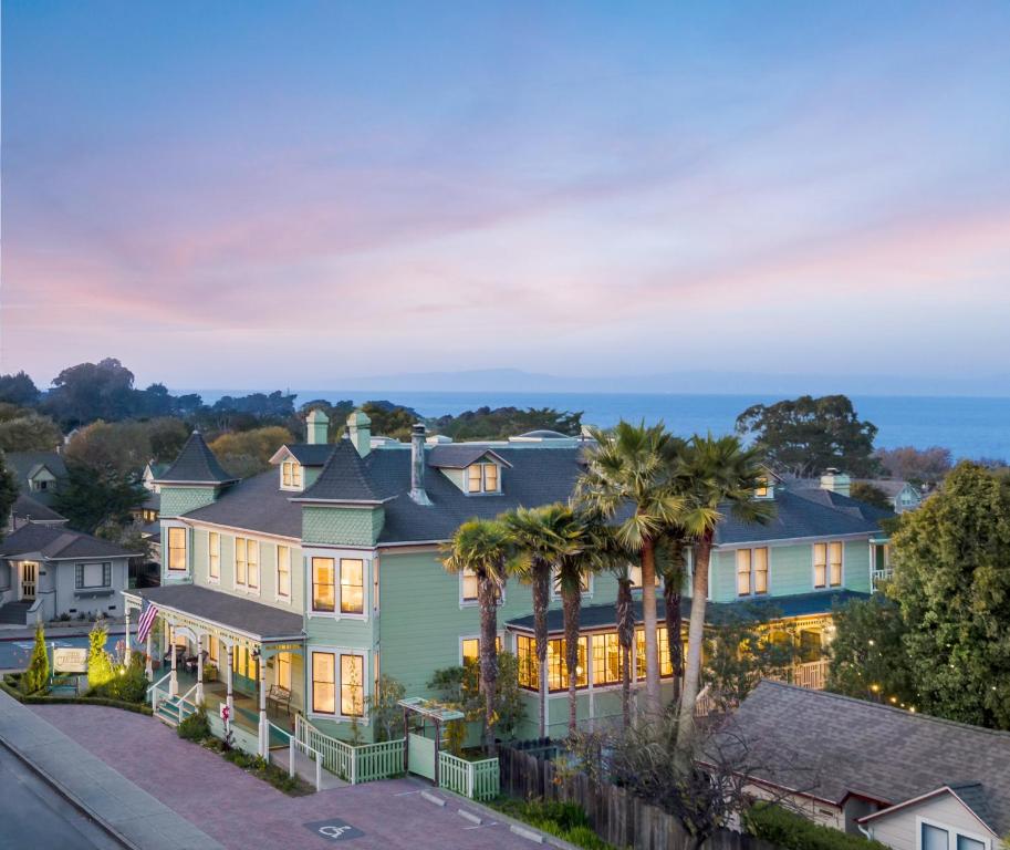 ein großes Haus mit Palmen davor in der Unterkunft Centrella Hotel, a Kirkwood Collection Hotel in Pacific Grove